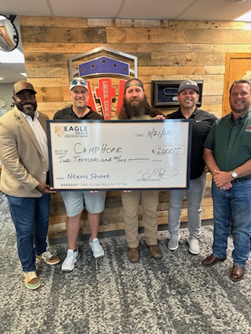 Organizers presenting a $2,000 donation check to Camp Hope