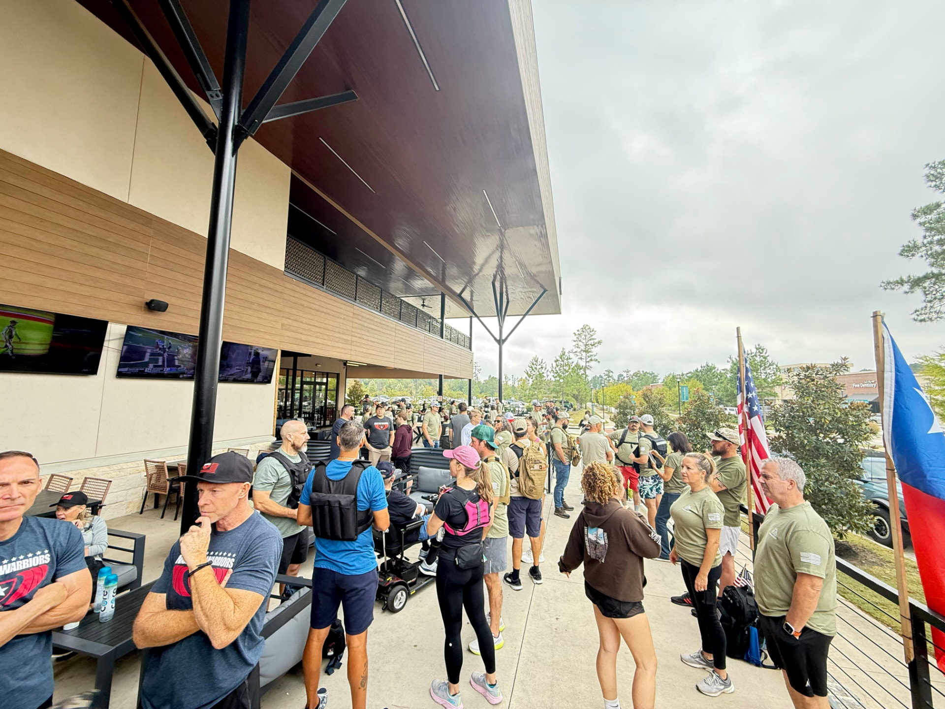Participants gathering with rucks and flags on the patio at Beerforest before the start