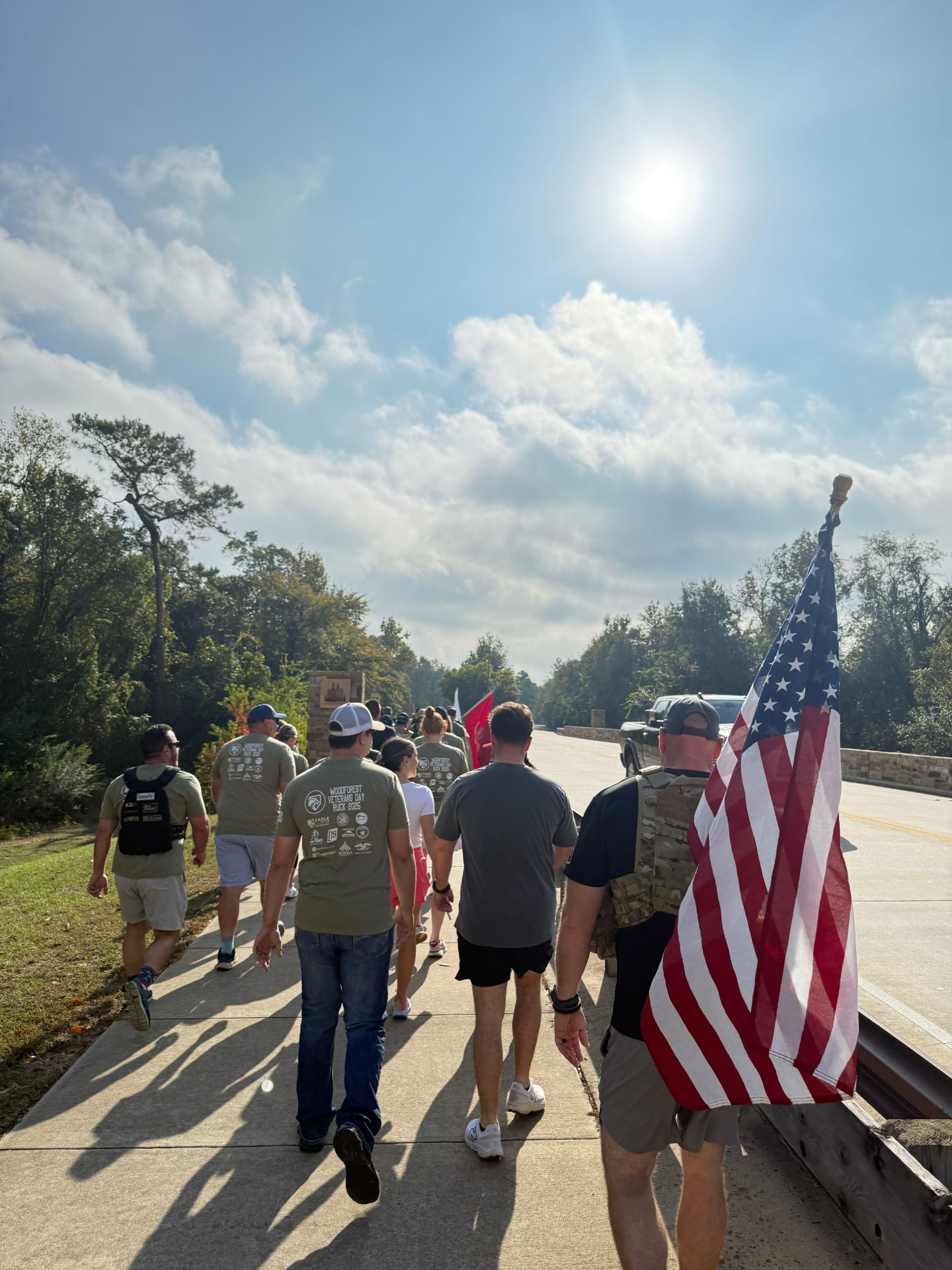 Rucker carrying a full-size American flag alongside the group on the bridge